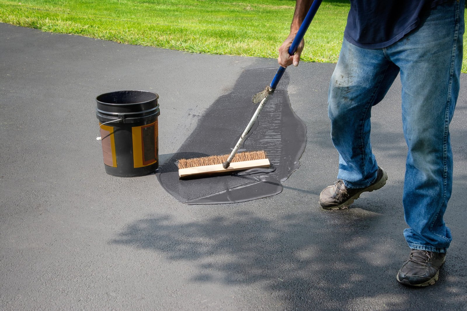 Homeowner Spreads Blacktop Asphalt Sealant On Driveway